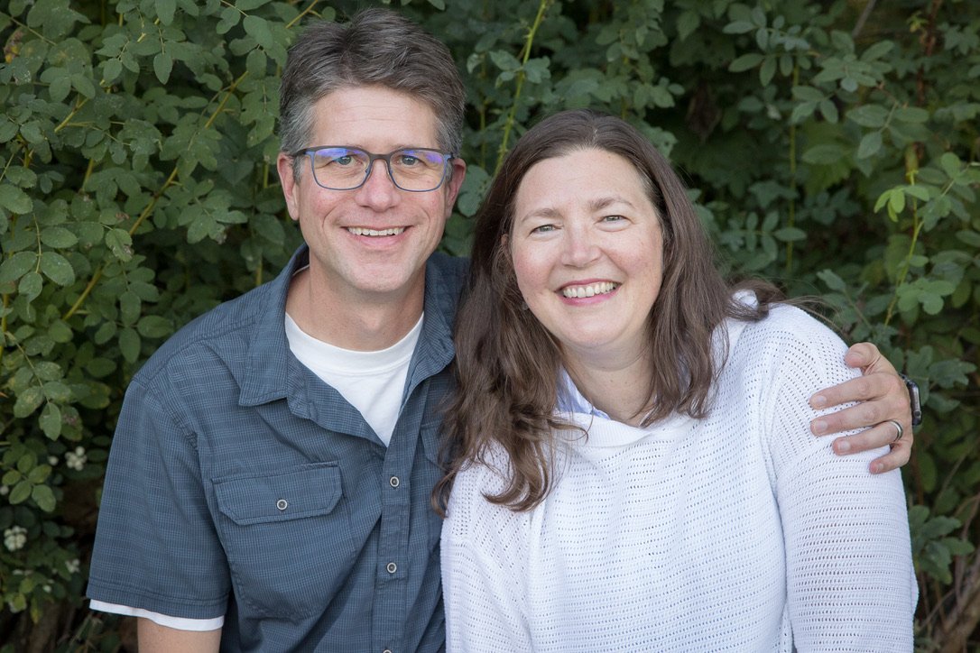 Rebecca Dale, MD, and Chris Dale, MD MPH, smiling together outdoors.
